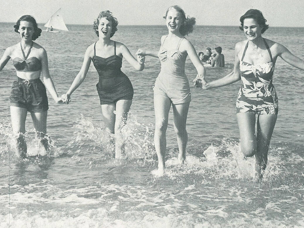Photo from 1976 Neptune Festival guide of young women running in waves