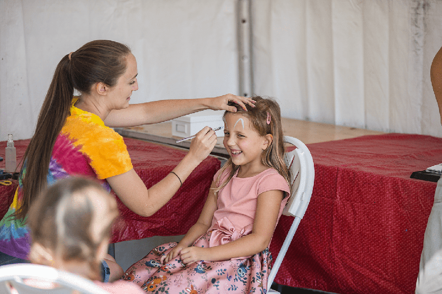 Young girl getting face paint applied at Poseidon's Playground