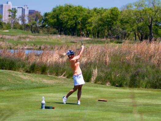 Golfer swinging at Neptune's Invitational Golf Tournament