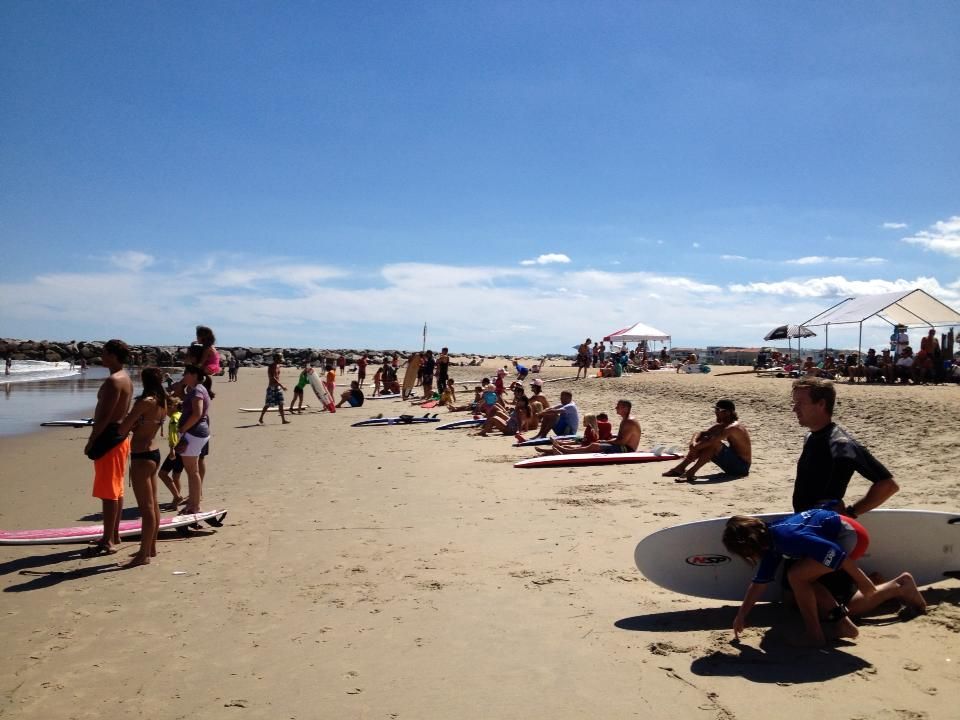 Group of surfers gathered on beach during Neptune's Surfing Classic