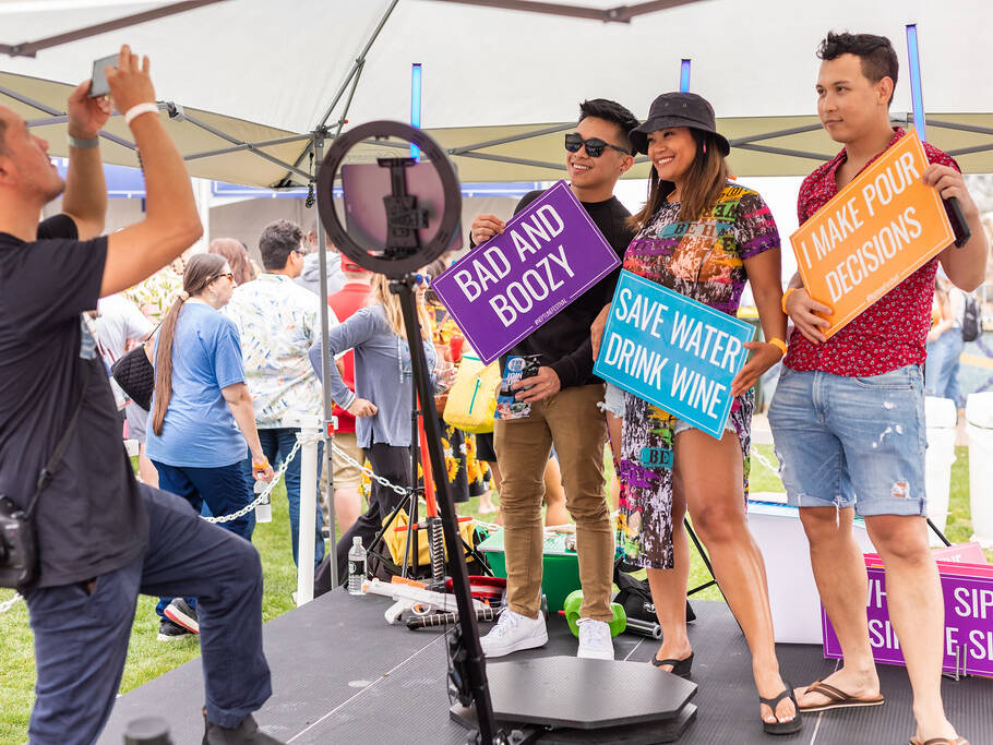 Group posing for photo with signs at Spring Wine Festival