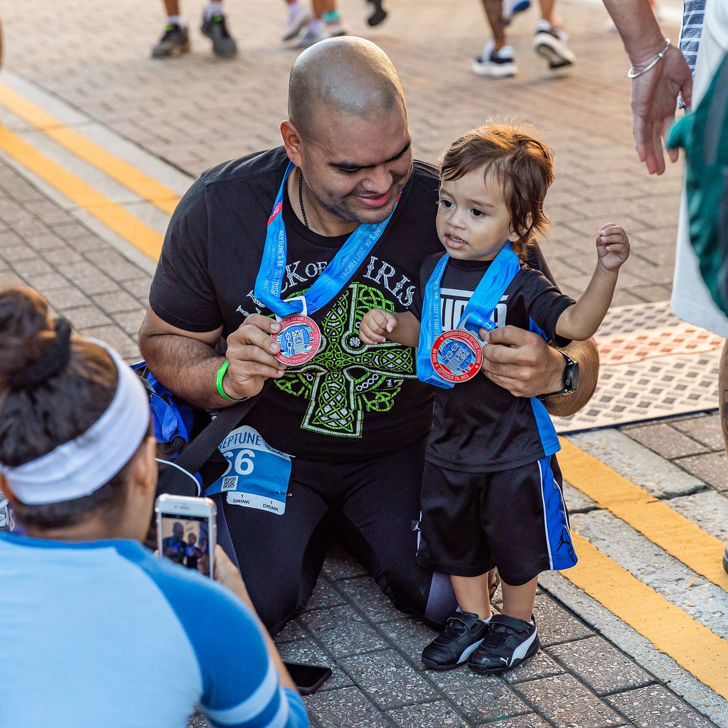 Man and young boy celebrating with medals after Neptune's 8K Race