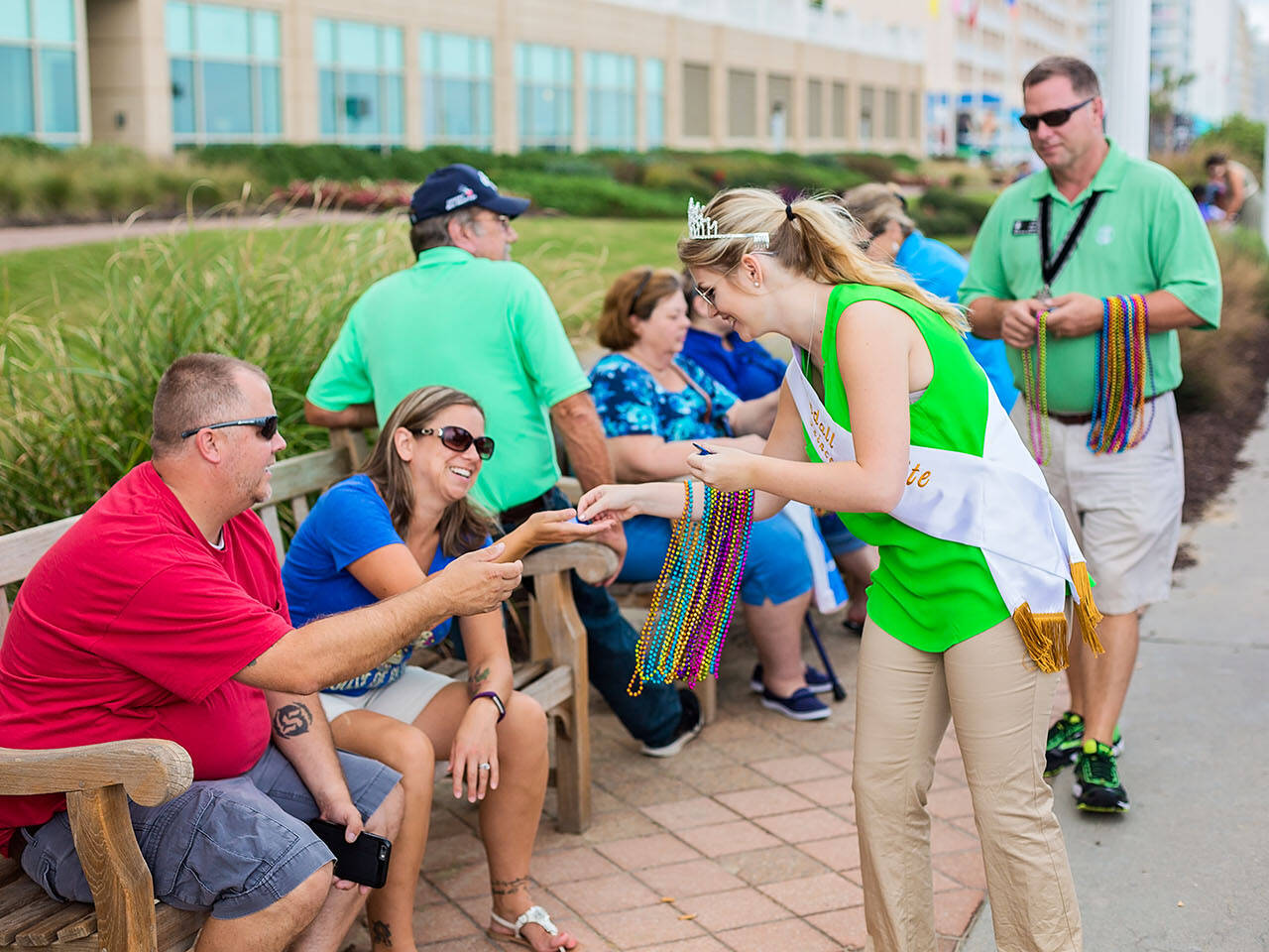 Royal Court handing out gifts to people on boardwalk