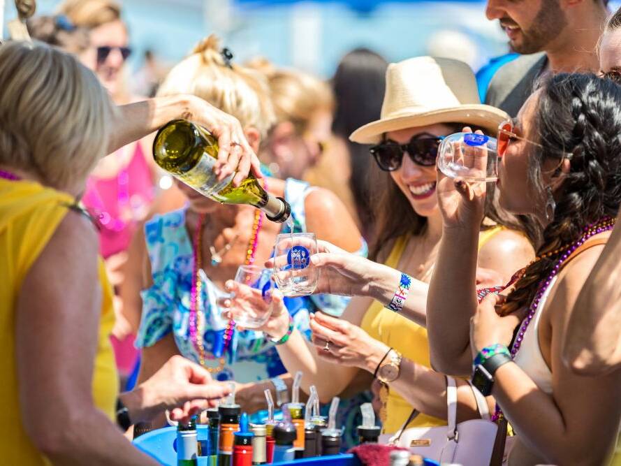 Group getting wine poured into glasses at Neptune's 25th Annual Fall Wine Festival