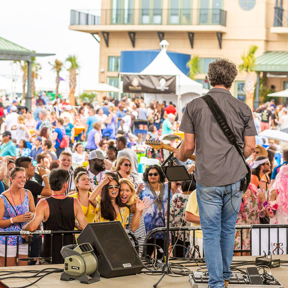 Performer playing music facing crowd at Neptune Festival event