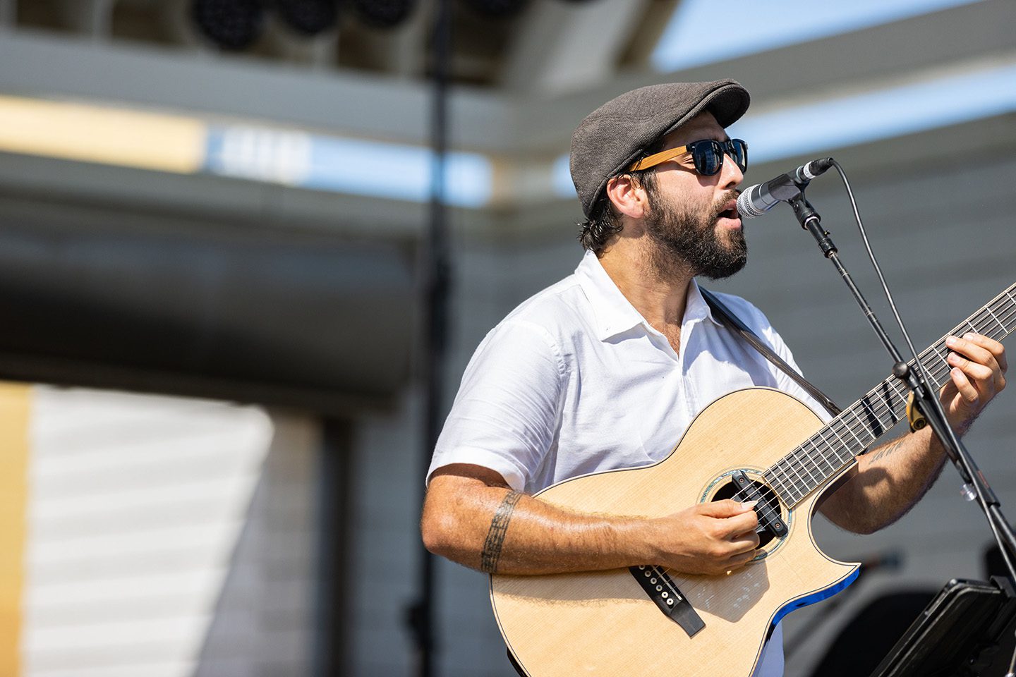 Performer playing guitar at Neptune Festival event